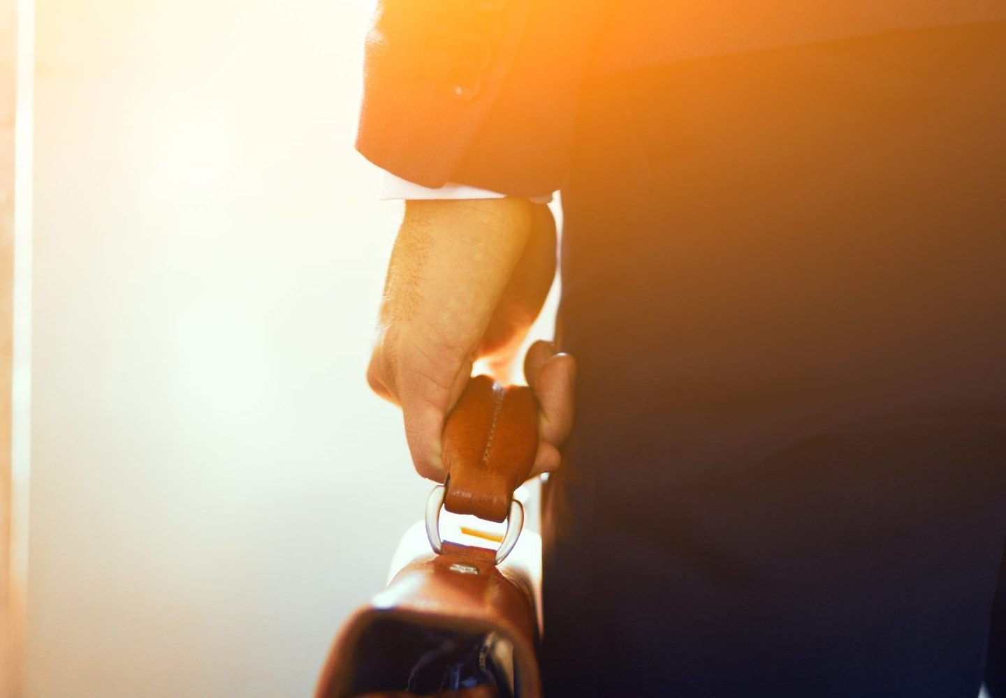 brown leather case hands man cropped picture businessman suit standing subway train holding brown bag his hand